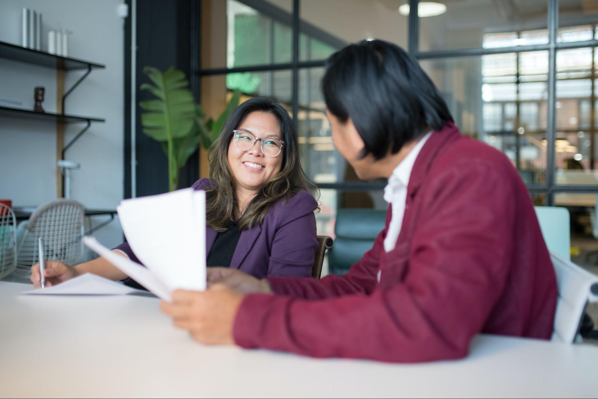 Woman looks at the computer screen of the woman beside her